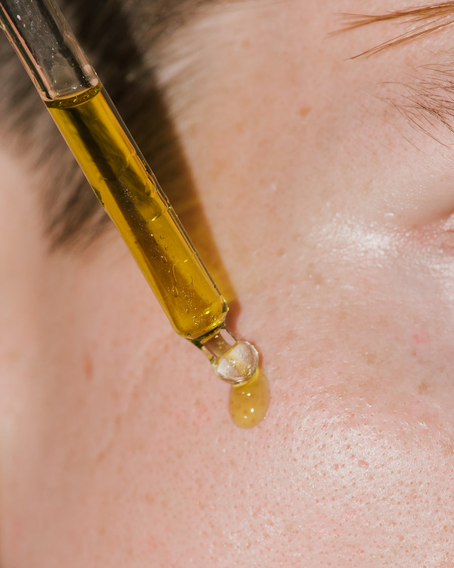 Botanical Recover Serum being applied to face.
