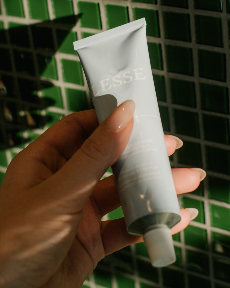 Holding Refining Cleanser in hand.