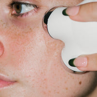 Close up of MINI Facial Toning Device on skin.