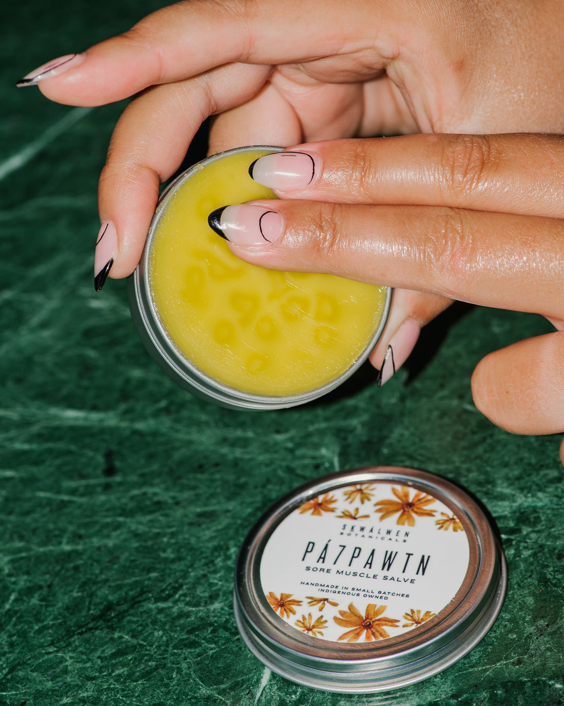 Close up og PÁ7PAWTN Nettle and Arnica Sore Muscle Salve tin.